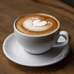 Una tazza di cappuccino con schiuma di latte vellutata e una spolverata di cacao su un tavolo di legno.